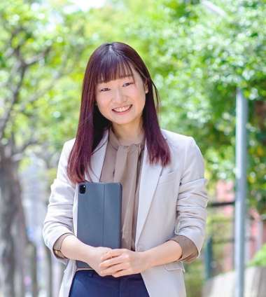 タブレットを抱えている笑顔の女性社員の写真
